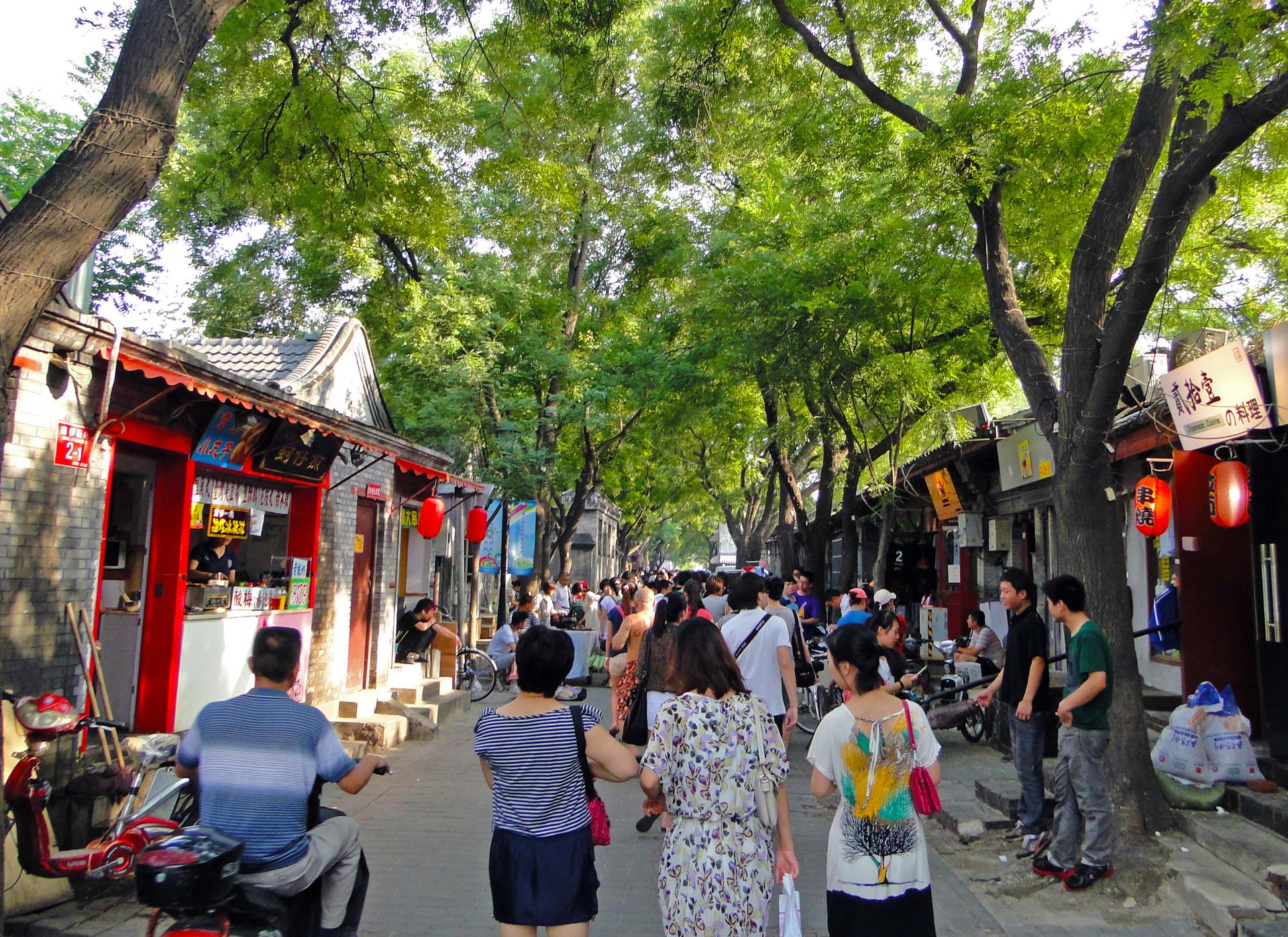 Crowds under the trees on Nanluoguxiang lane, next door to Mao'er Hutong