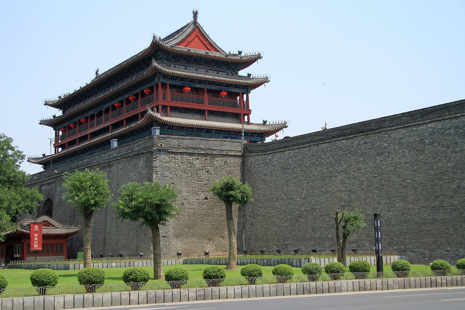 Xi'an's Ming-era gate tower and the long grey stretch of the city wall under a blue sky