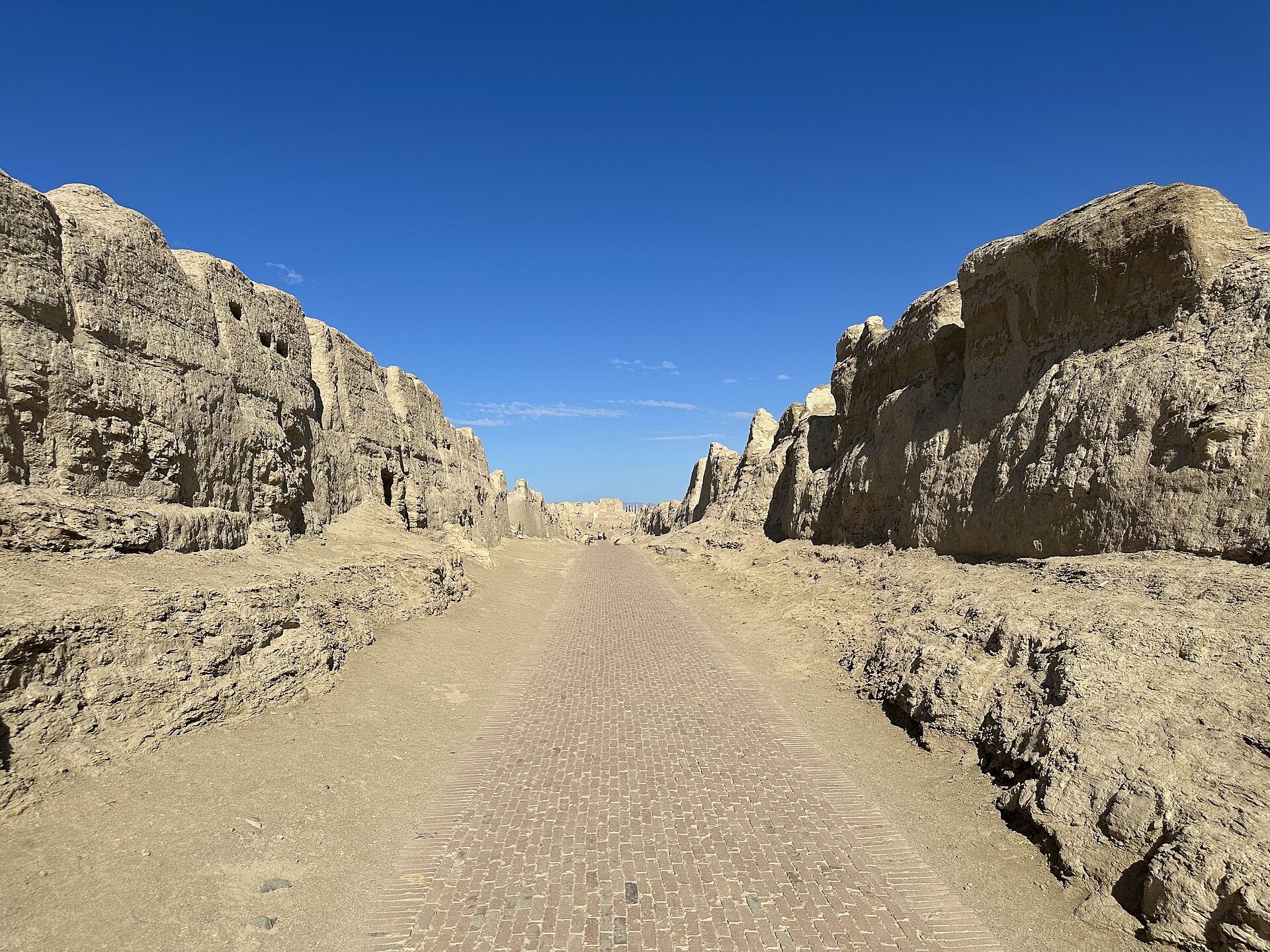 The central avenue of Jiaohe ancient city, flanked by high eroded earthen walls
