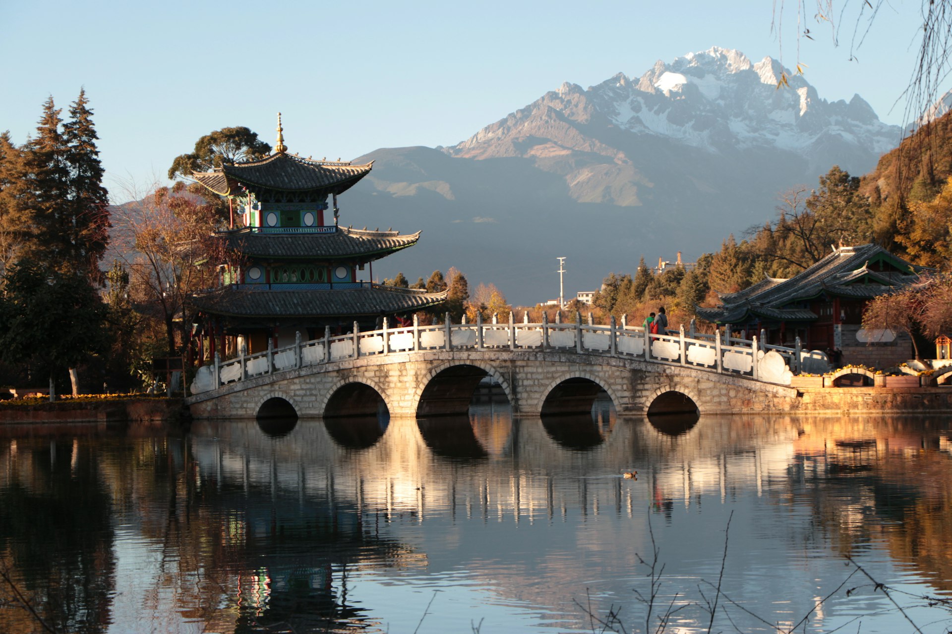 Black Dragon Pool at dawn: five-arch bridge, pavilion, and the Jade Dragon Snow Mountain reflected