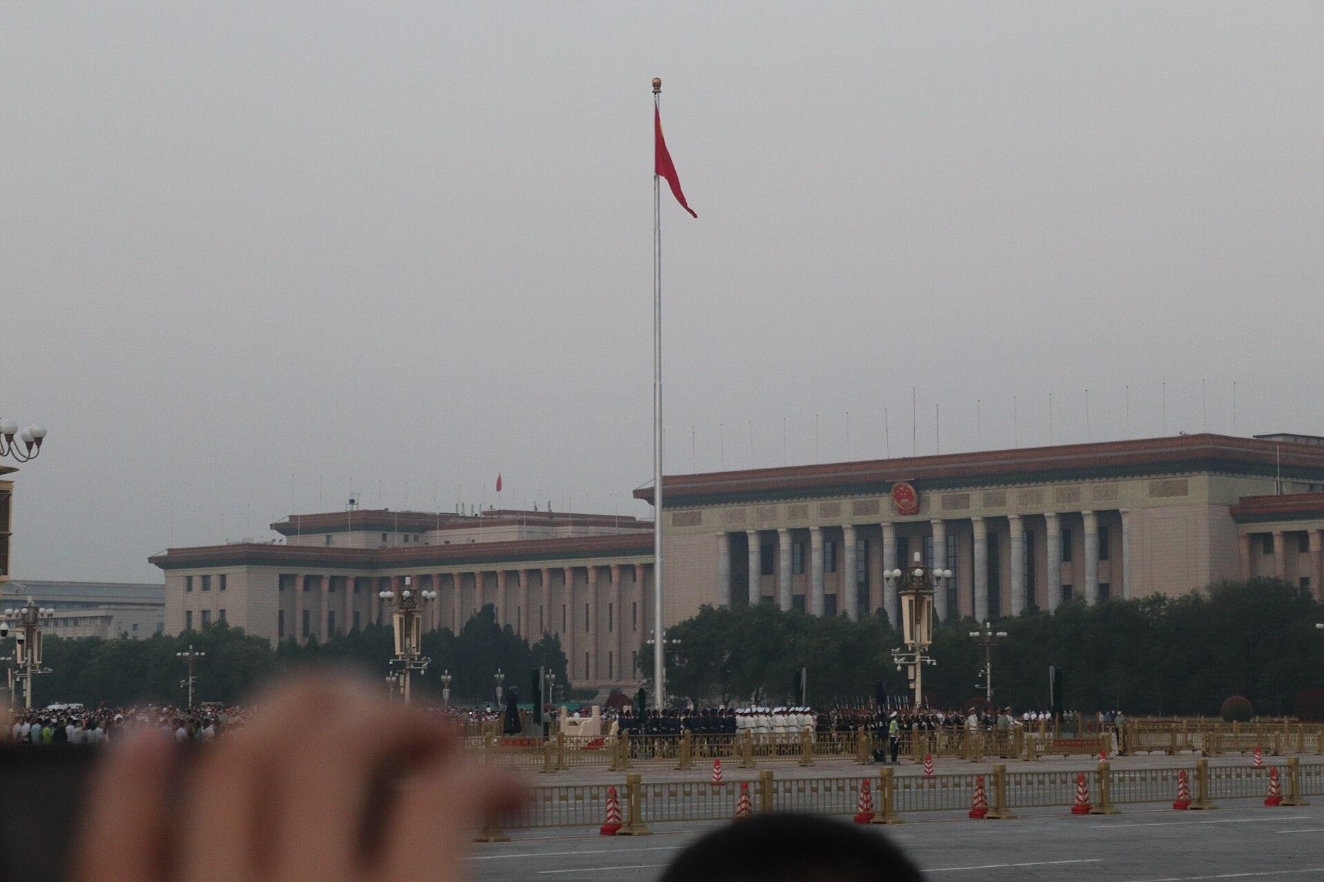 The national flag raised over Tiananmen Square at dawn with the honour guard below
